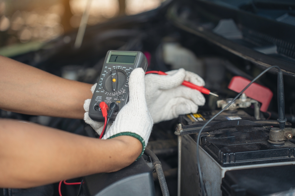 Close-up,Of,Mechanic,Holding,Voltmeter,To,Check,Voltage,Car,Battery